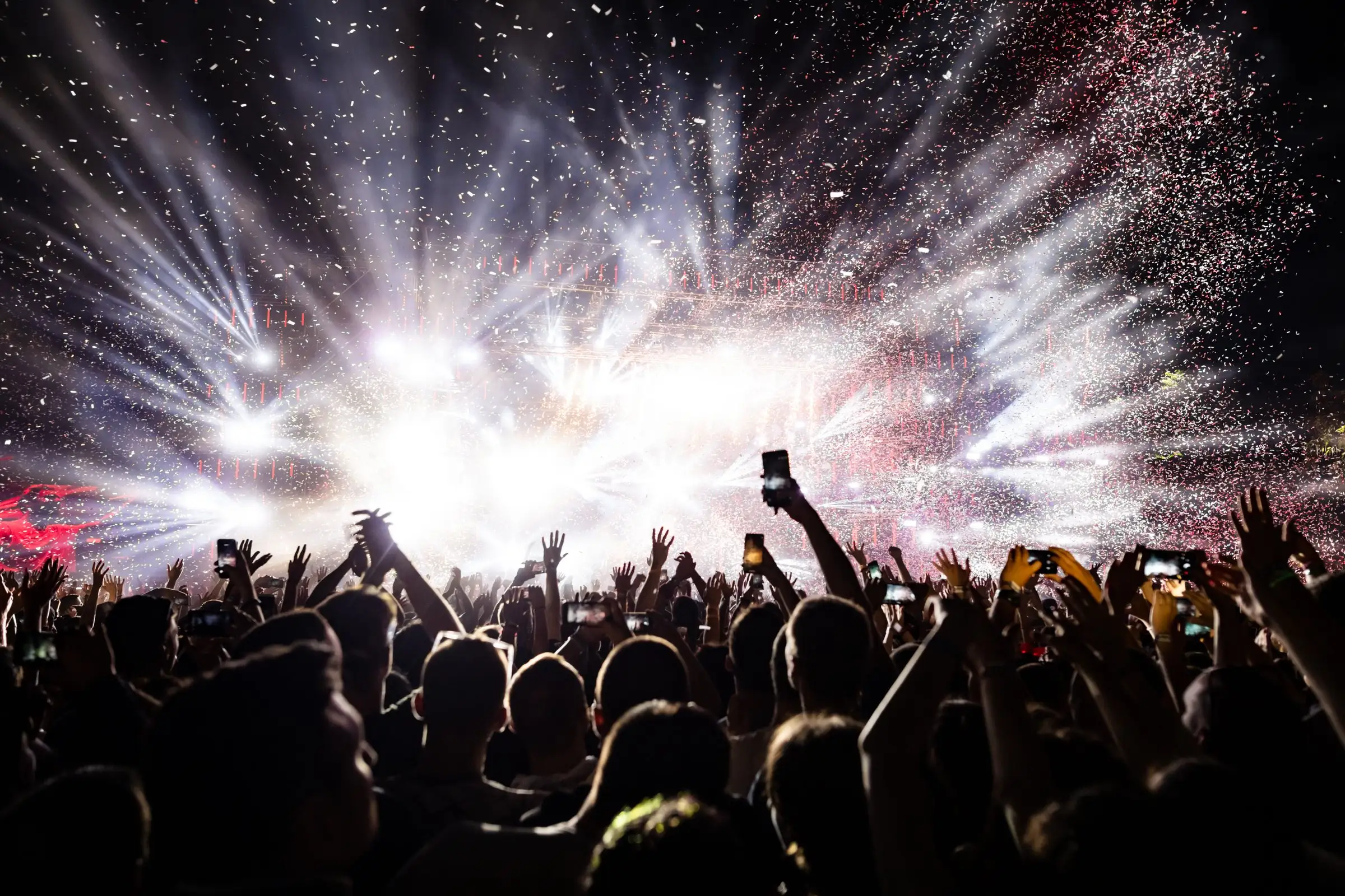 Pubblico di un concerto tra coriandoli e luci