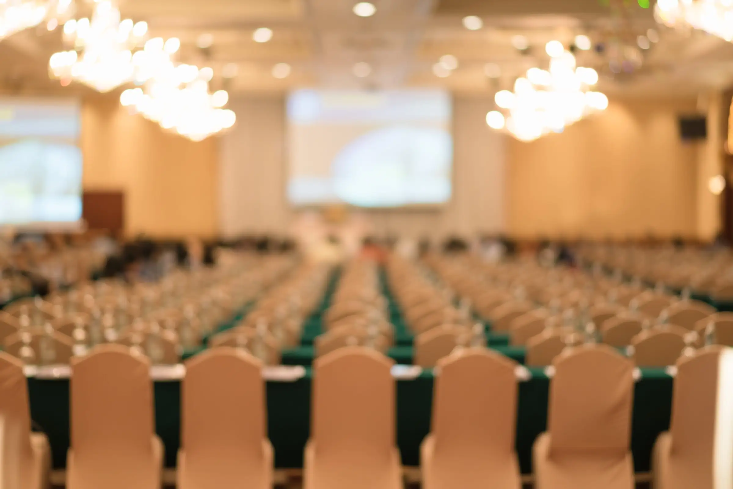 Sala congressi con lampadari e file di sedie
